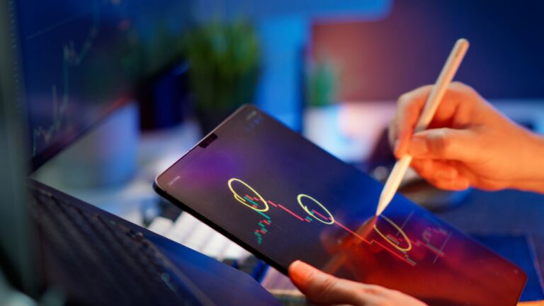 Person analyzing revenue trends on a tablet with digital pen.